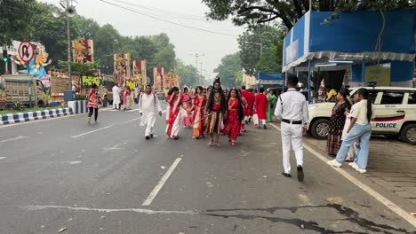 people dressed as god shiva and parvati and in red white saree at durga puja carnival procession in red road of kolkata, india.