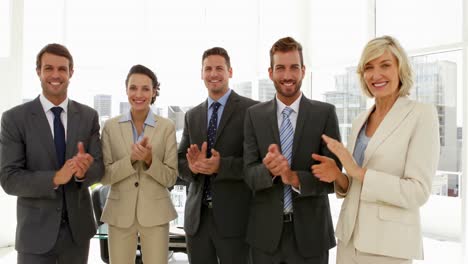 business people clapping at the camera