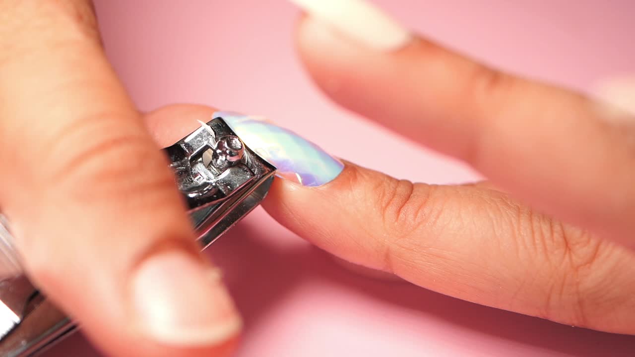 Close-up of Hands Trimming Fingernails with a Nail Clipper