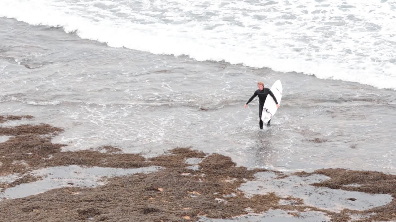 서퍼는 상징적인 바위 형태를 향해 습니다.