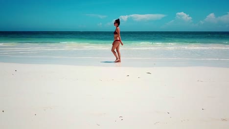 Female-Tourist-In-Bikini-Walking-On-Pristine-White-Sand-Beach-In-Kilifi,-Kenya-On-A-Sunny-Summer-Day