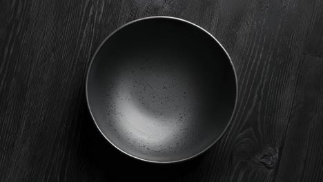 empty black bowl on a wooden table