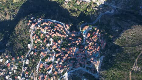 Vista-Panorámica-Del-Pueblo-De-Dhermi-Con-Tejados-Rojos-En-La-Riviera-De-Albania,-Perspectiva-Aérea-Escénica-Del-Encanto-Mediterráneo