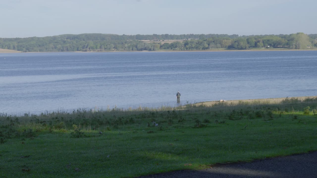 Trout fly fishing on Rutland Water man-made reservoir lake, outdoor England