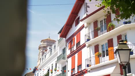 European-Basque-French-Houses-on-the-coast,-bright-sunny-day-with-trees,-handheld-drifting-shot