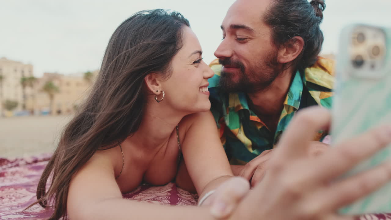 Couple Kissing on the Beach Taking a Selfie
