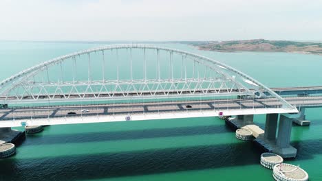 aerial view of a modern arch bridge over a body of water