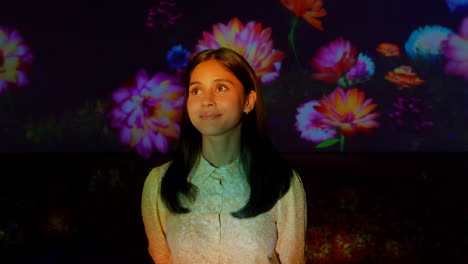 woman in an immersive floral projection art installation