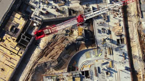 high building construction site. big industrial tower crane with blue sky amd cityscape on background. concrete plates weight balance. counterweight. aerial drone view. metropolis city development