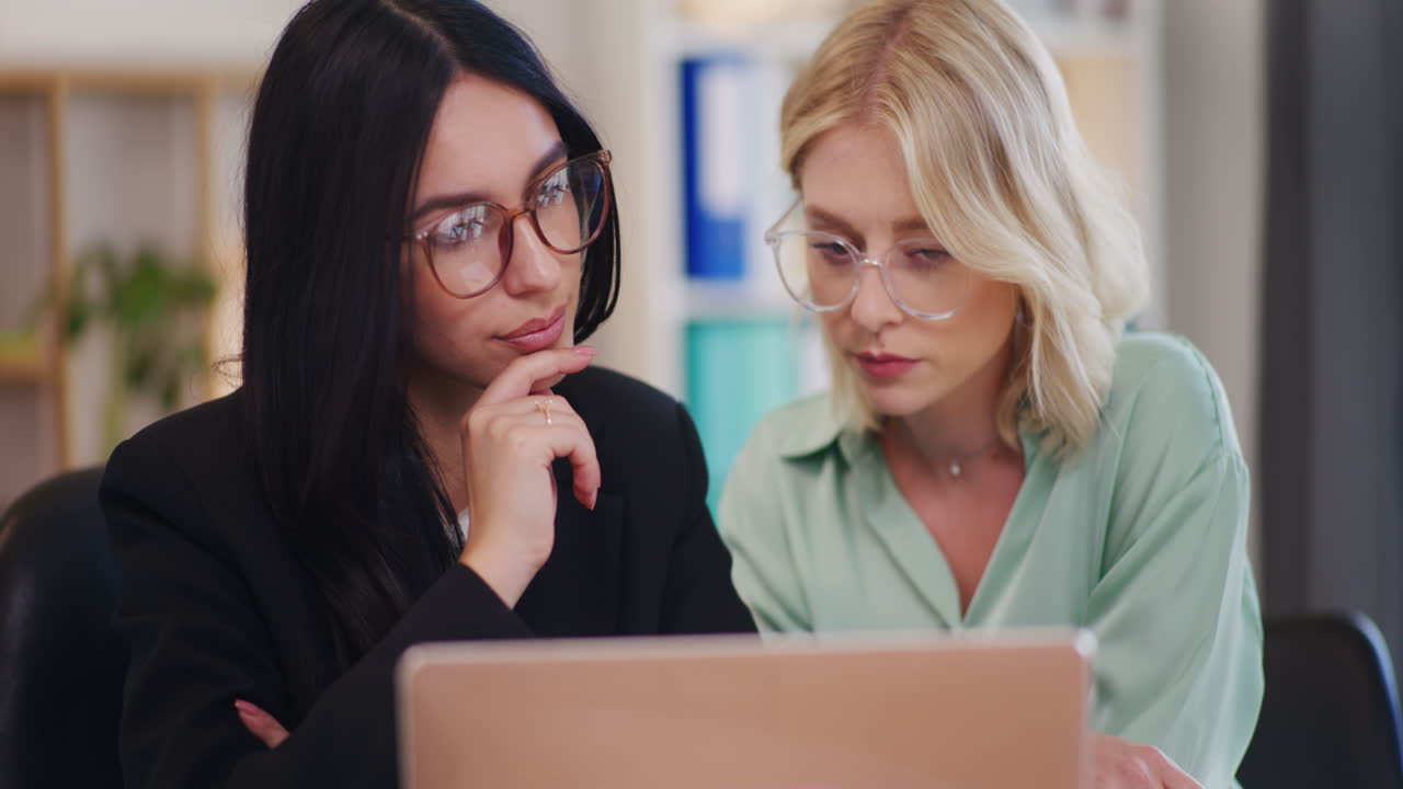 Two Women Discuss and Work on Business Project
