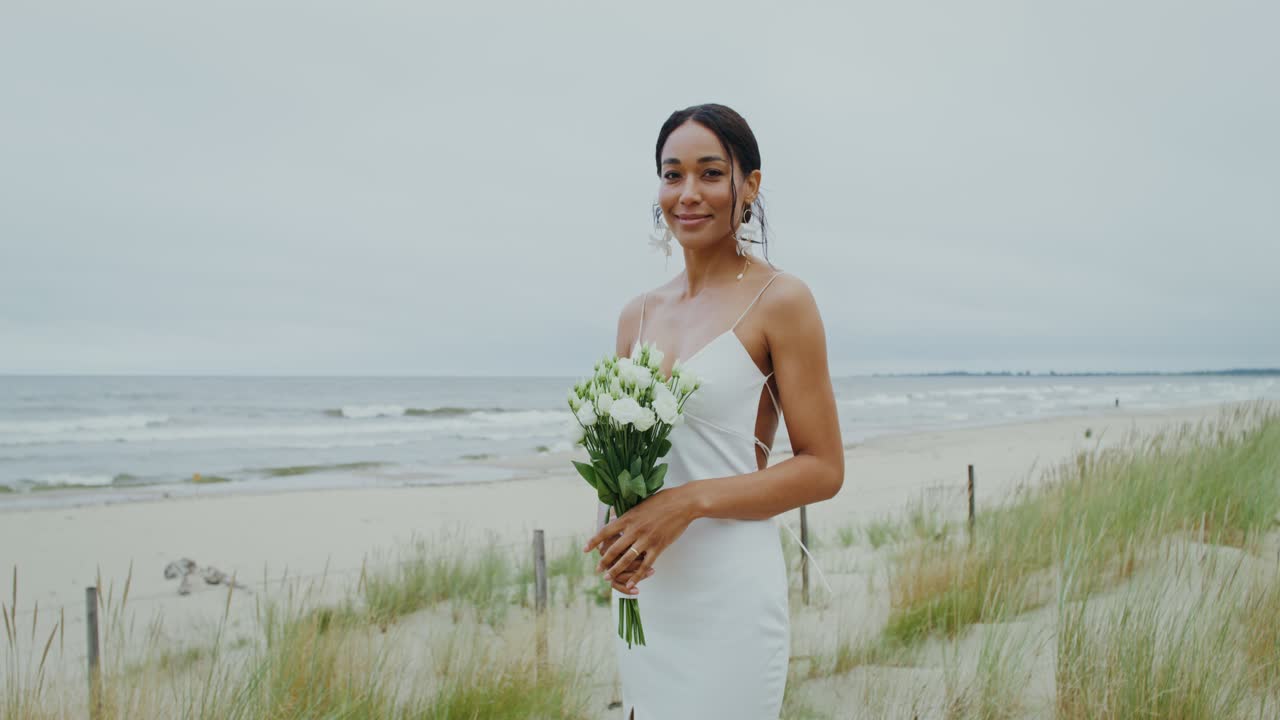 Mariée sur une plage avec un bouquet