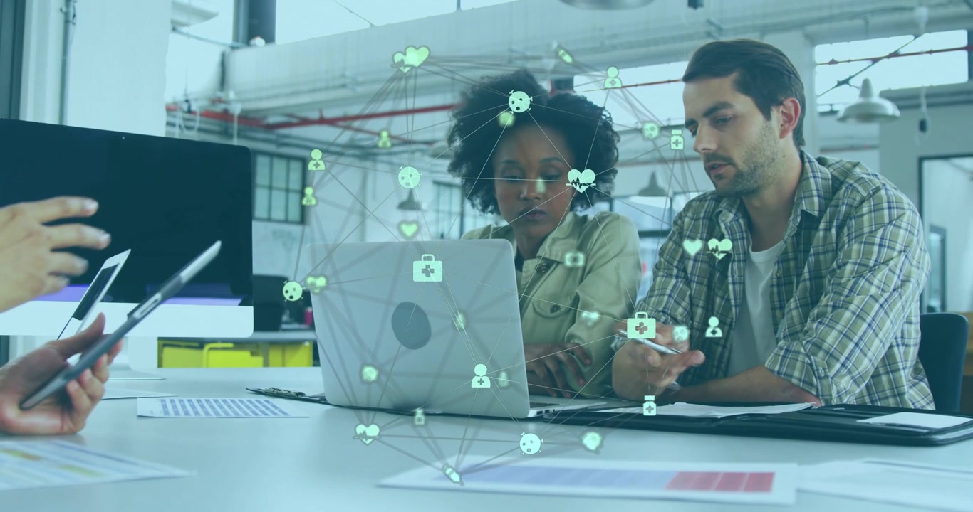 Vertical video: Reacting to tablet at work woman in coat and coworker checking laptop green overlay