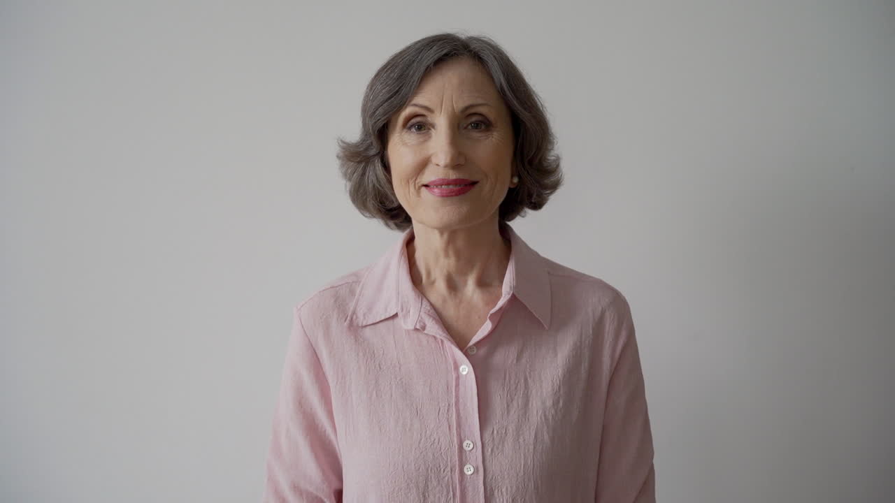 Happy Senior Woman Jumping And Cheering While Looking At Camera On White Background