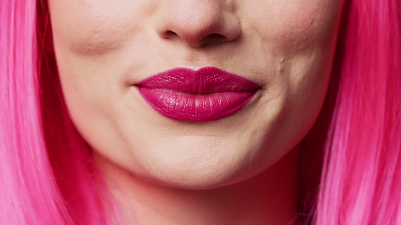 Cheerful pretty adult with pink lipstick biting lips in studio