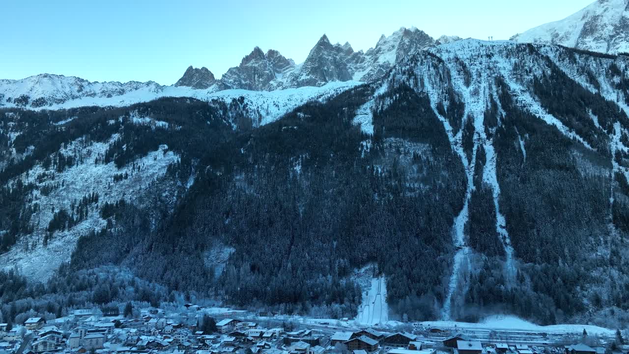 Aerial Tilt down from dramatic Alps mountains to reveal the ski resort and town of Chamonix, France