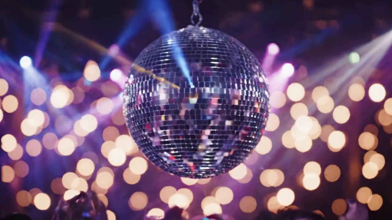 En spektakulær nattelivsscene med en glitrende diskokugle og en energisk menneskemængde, der danser under farverige lys i en fortryllende atmosfære.