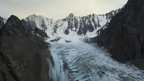 rotating revealing drone shot of an opening in the ak-sai glacier in kyrgyzstan