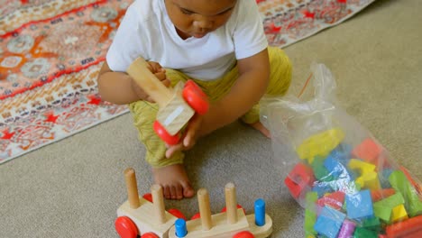 High-angle-view-of-cute-little-black-boy-playing-and-crouching-on-floor-of-comfortable-home-4k