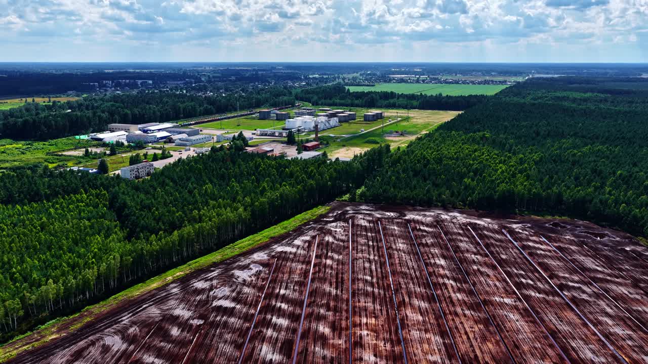 Agriculture land crop field soil fresh layer ready to be planted, industrial city outskirts