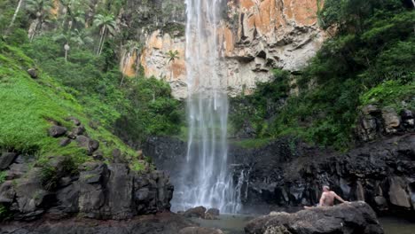 persona relajándose cerca de una cascada panorámica