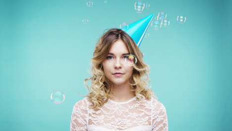 Single-woman-blue-hat-is-sad-in-bubble-shower-slow-motion-photo-booth-blue-background