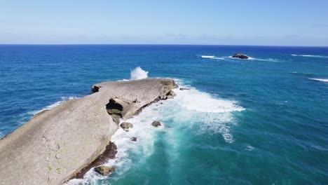 Aerial-view-of-a-rugged-coastal-outcrop-with-waves-crashing-against-its-rocky-edges