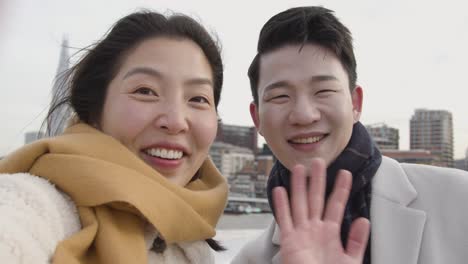 pregnant young asian couple in london uk making video call home on phone showing sonogram of new baby to family 1