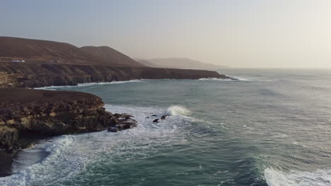 panoramic view of waves crashing onto the cliffs and caves of ajuy