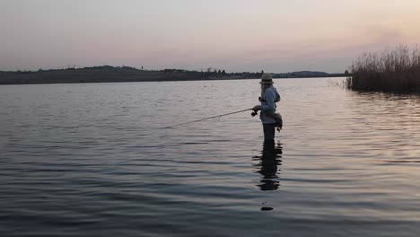 A-girl-fishing-in-a-calm-lake-during-a-tranquil-afternoon-in-Africa