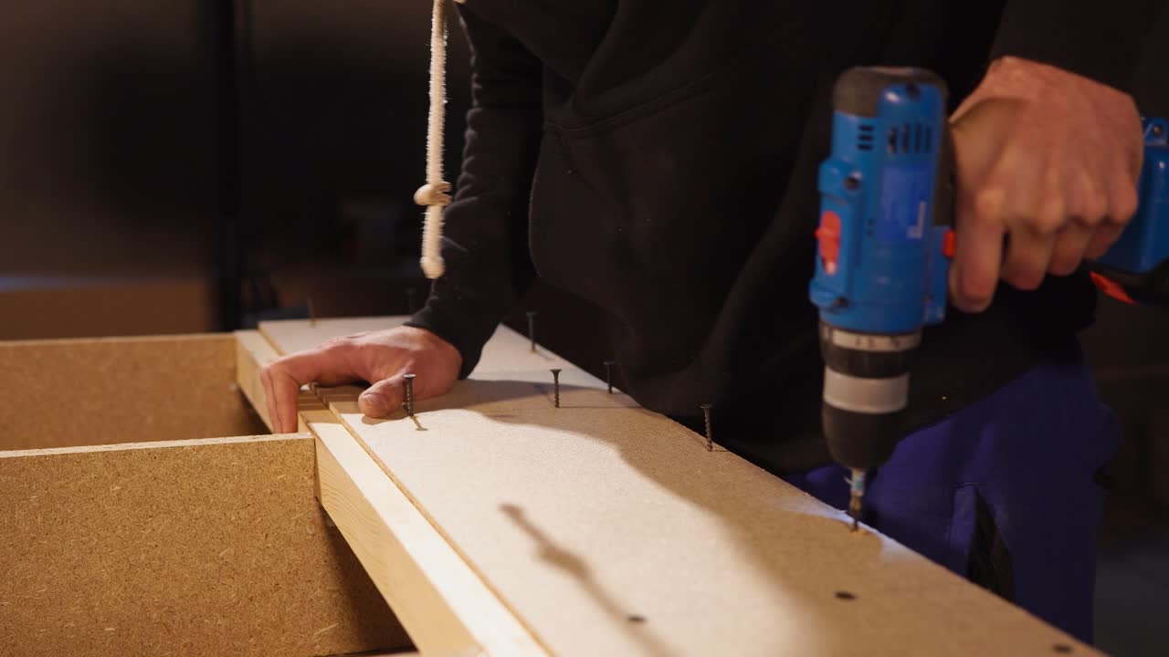 hombre usando un taladro para montar muebles de madera
