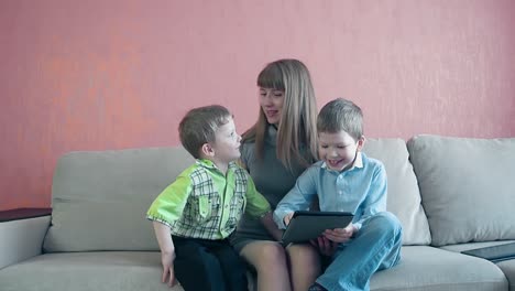Mutter-Und-Zwei-Kleine-Söhne-Sitzen-Auf-Dem-Sofa-Und-Spielen-Auf-Einem-Tablet