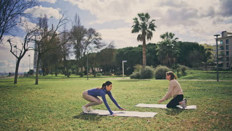 fitness women practicing burpee power workout. two girls doing push ups and jump