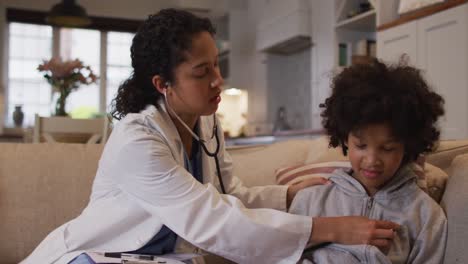 Mixed-race-female-doctor-examining-mixed-race-girl-at-home