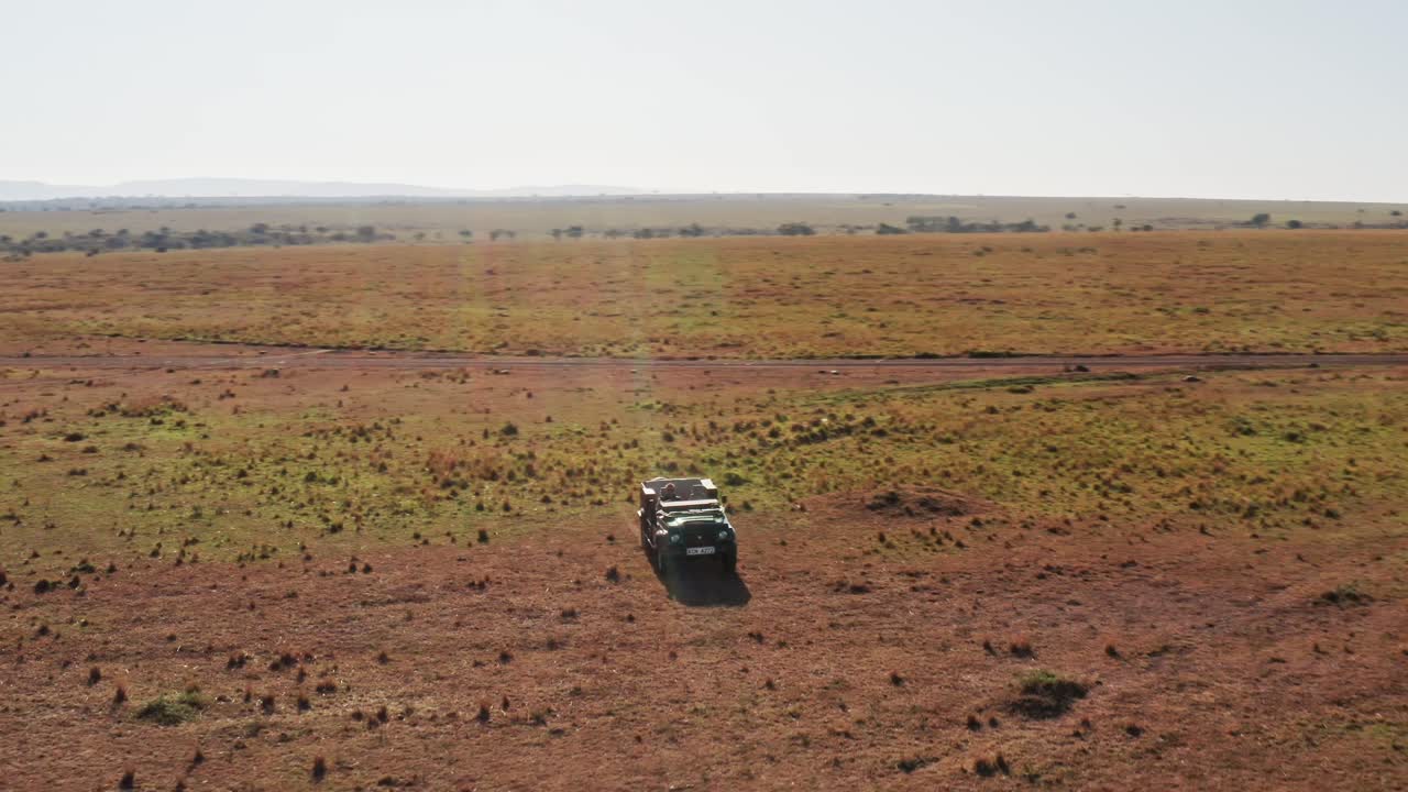 fotografía aérea de un fotógrafo de vida silvestre conduciendo un vehículo de safari en la reserva nacional de sabana de maasai mara, kenia, áfrica con hermosos paisajes, la conservación del norte de masai mara