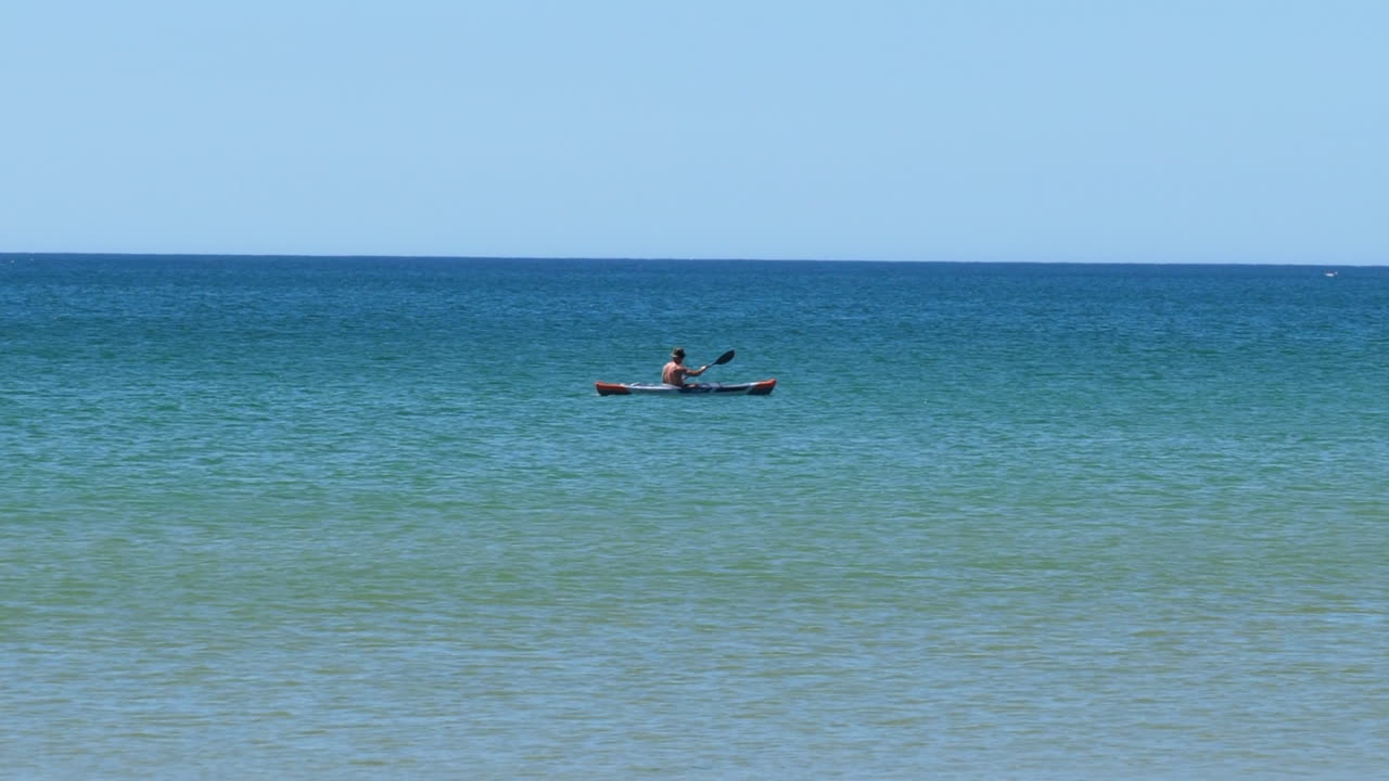 hombre kayak en el mar, día soleado. tiro de seguimiento