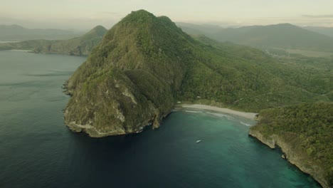 aerial view of a secluded tropical beach and lush green mountain
