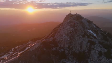 uma vista aérea deslumbrante da montanha corno bianco ao pôr-do-sol com uma cruz no pico