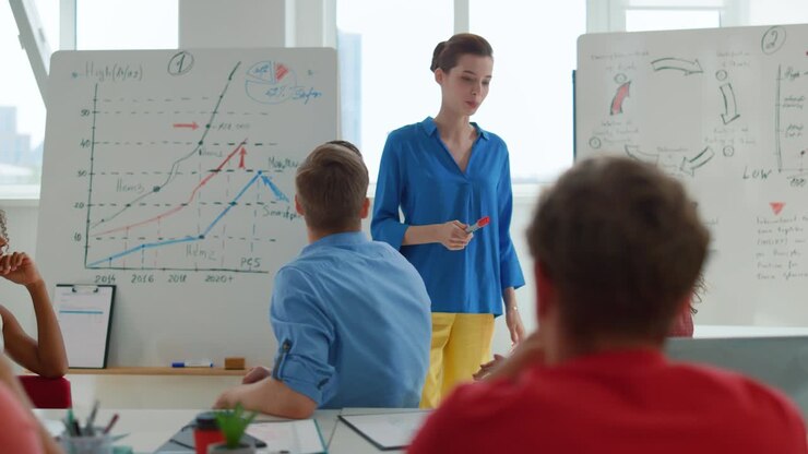 Serious woman leader speaking to employees in modern office