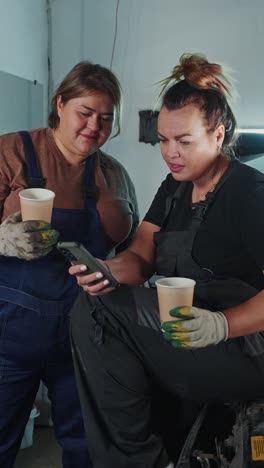 two women mechanics discussing a repair issue