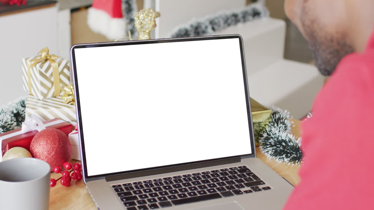 hombre afroamericano con sombrero de santa teniendo llamada de video portátil con espacio de copia