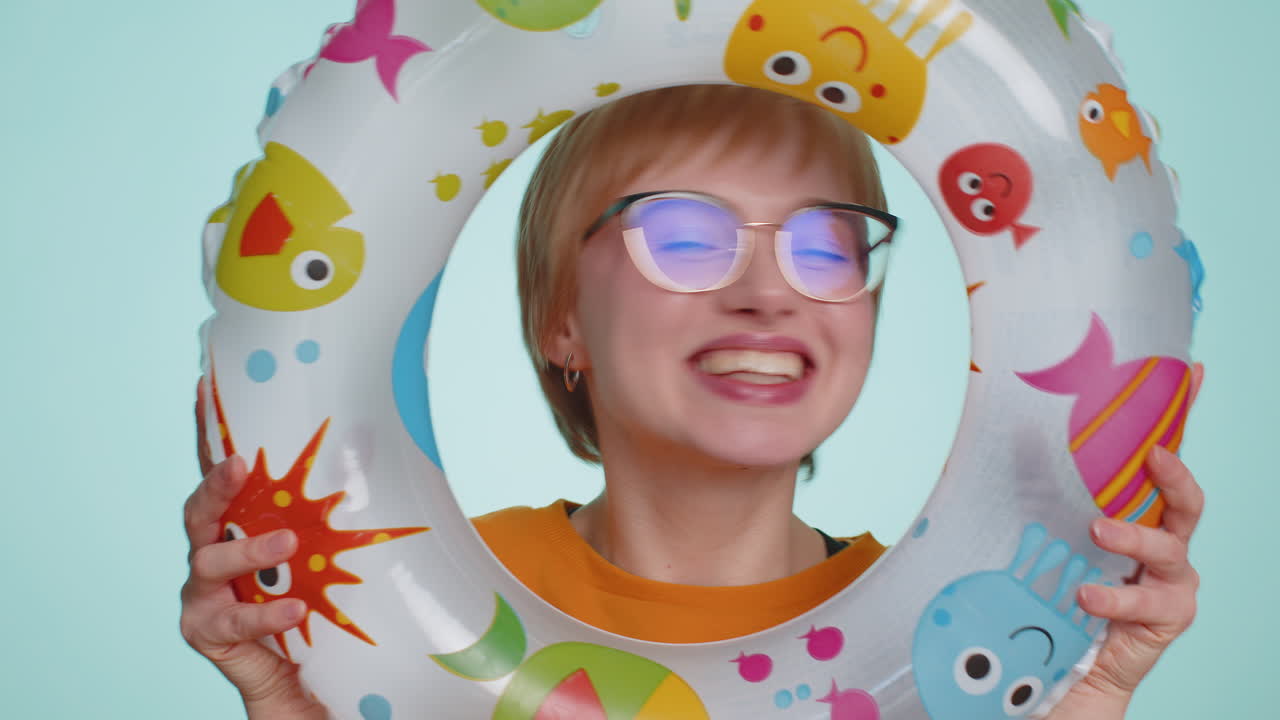 Funny young tourist woman looking out of rubber swimming ring summer vacation time sea travel