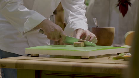 male hands carefully slicing seared tuna steak with chef knife at kitchen