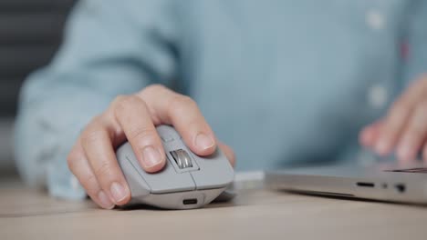 close-up hand of a businessman using wireless or bluetooth mouse. scrolling the wheel working with a pc or laptop.