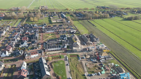 Flying-over-construction-site-at-the-edge-of-a-newly-built-suburban-neighborhood