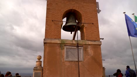 incline hacia abajo sobre la famosa torre del reloj en la parte superior de la alhambra con los turistas