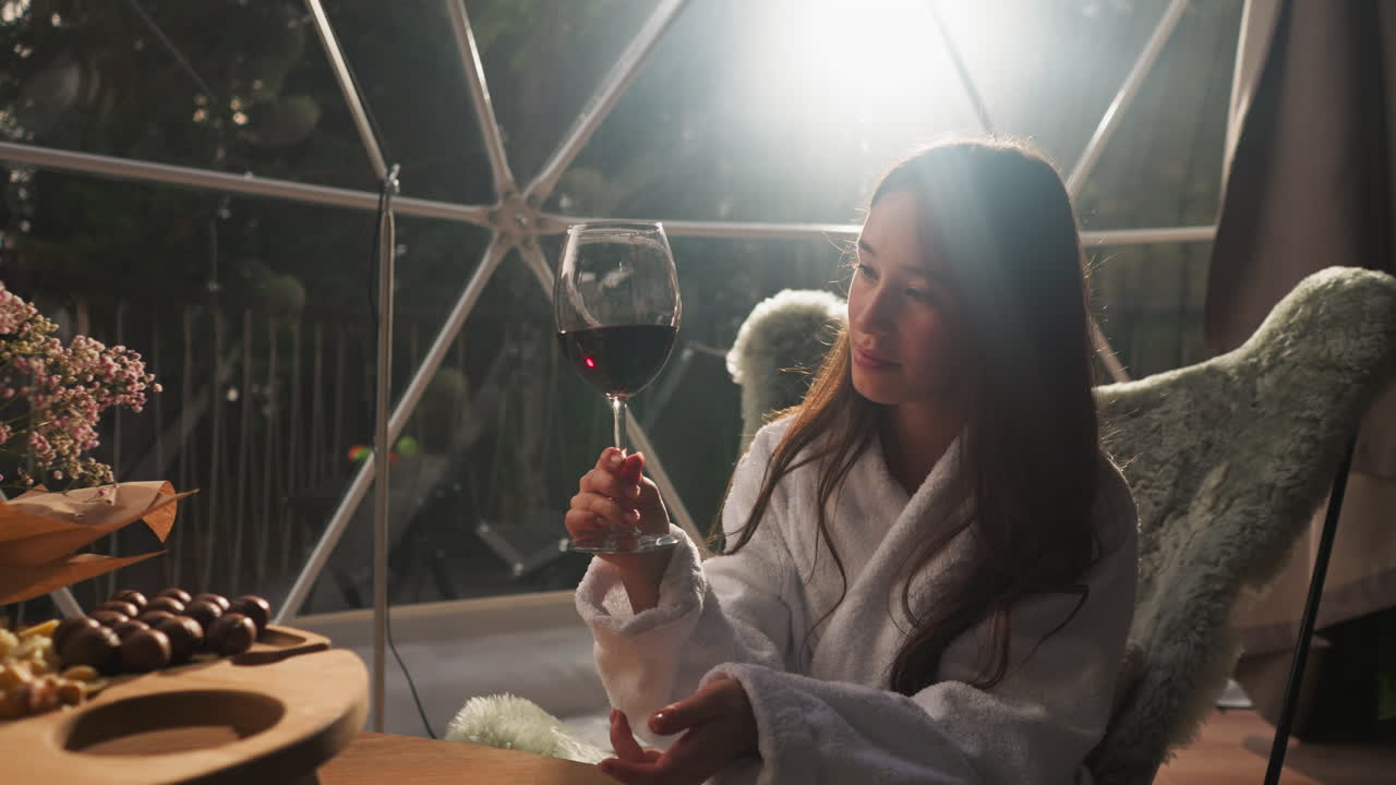Girl enjoying red wine in a geodesic dome
