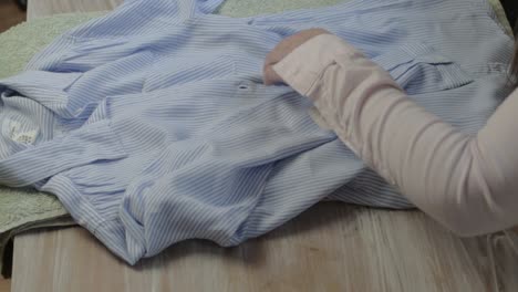 woman folding shirt after doing the laundry