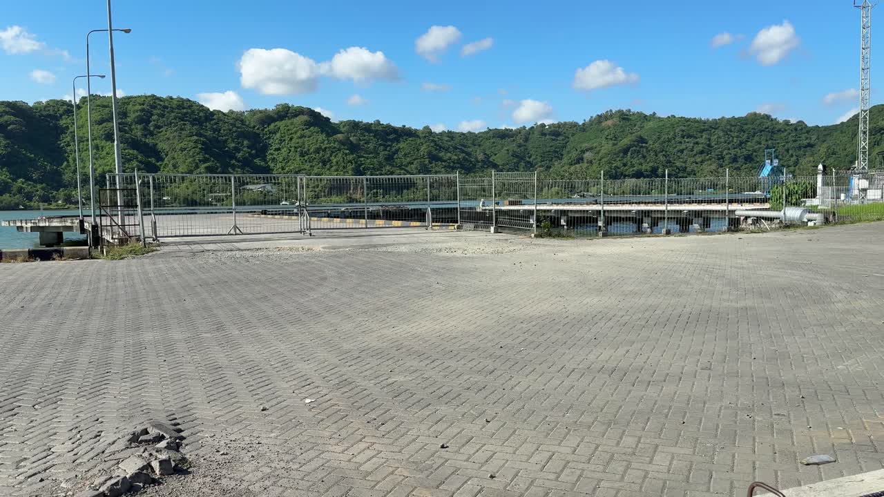 Empty Port Entrance with Paved Ground and Green Hills