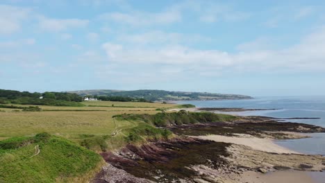 Traeth-Lligwy-Anglesey-eroded-coastal-shoreline-aerial-circling-view-across-north-wales-weathered-coastline