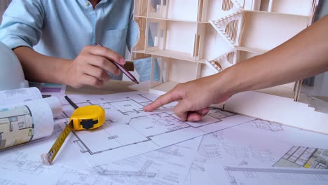 the partnership engineering man or co-workers working on a project and discussing together with looking at blueprint paperwork